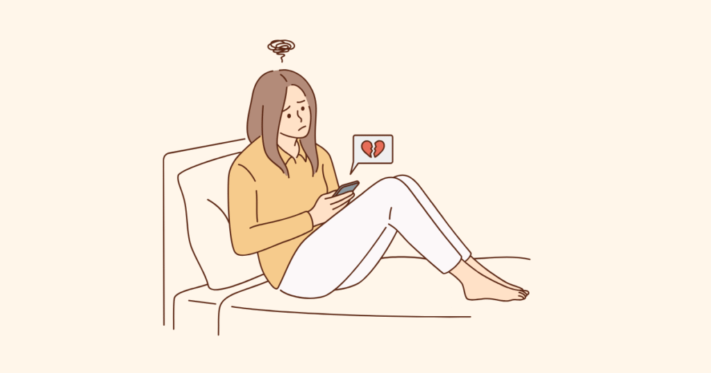 スマホをベッドの上で持つ女性（失恋している）